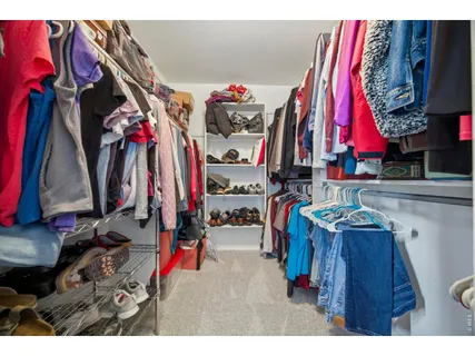 a view of walk in closet with clothes