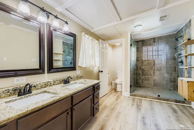 a bathroom with a granite countertop sink mirror and shower