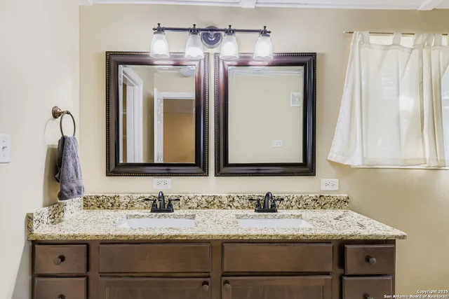 a bathroom with a granite countertop sink and a mirror