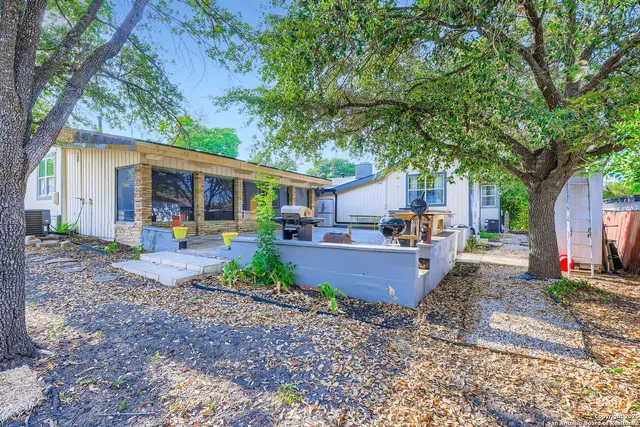 a view of a house with backyard and sitting area