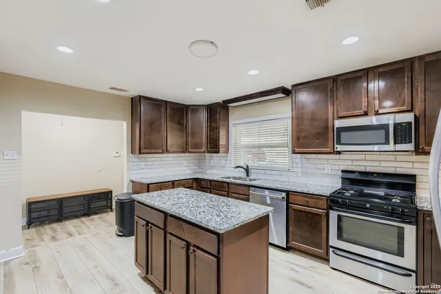 a kitchen with stainless steel appliances granite countertop a stove and a sink