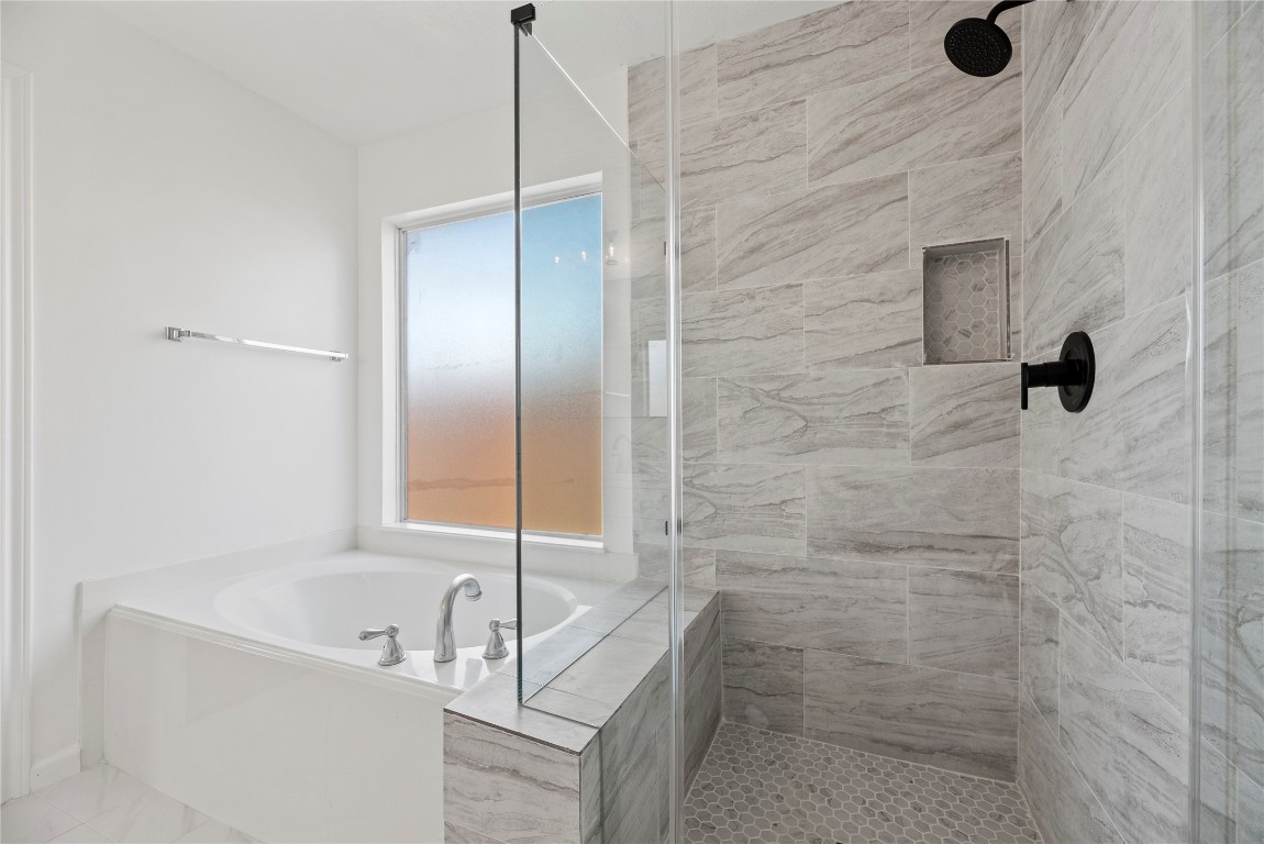19910 Rustic Lake Lane Cypress, TX 77433 - Photo 8 of 21 This renovated bathroom comes with a soaking tub, separate vanities, a modern glass-enclosed shower with beautiful tile work throughout and plenty of space in this light and bright primary bathroom.