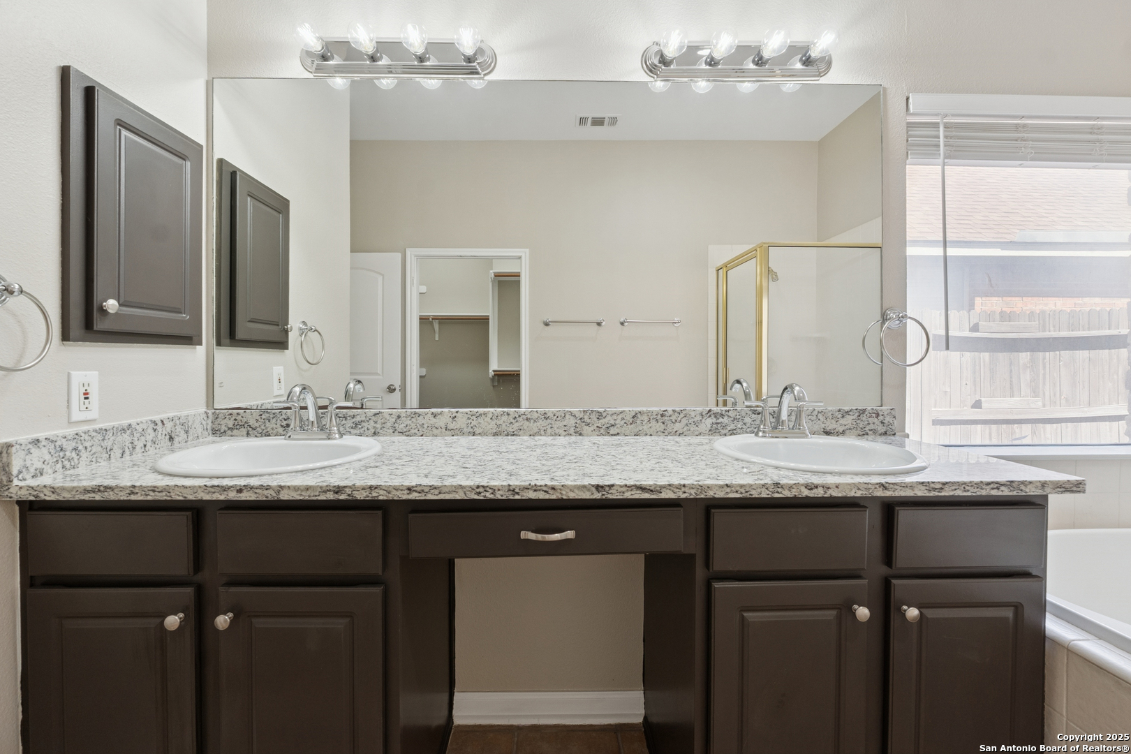 1815 Indian Paint Brush Road San Antonio, TX 78232 - Photo 21 of 38 a bathroom with a granite countertop sink a large mirror and a window