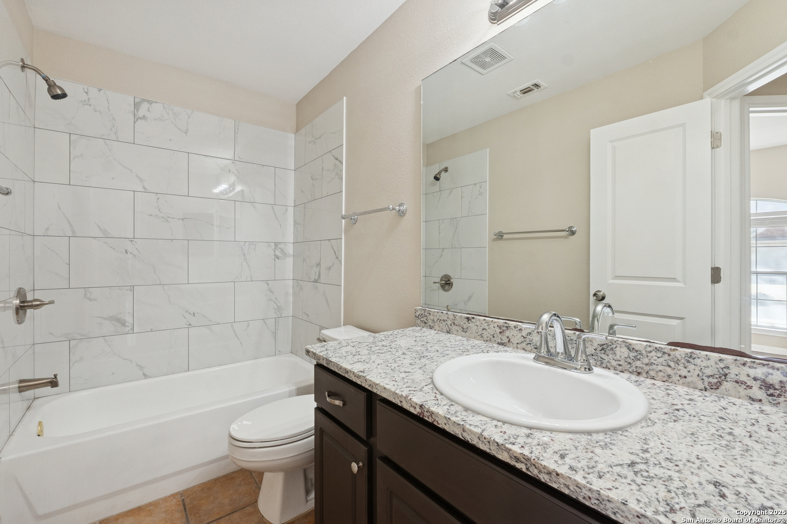 1815 Indian Paint Brush Road San Antonio, TX 78232 - Photo 32 of 38 a bathroom with a granite countertop sink a toilet a mirror a bathtub and shower
