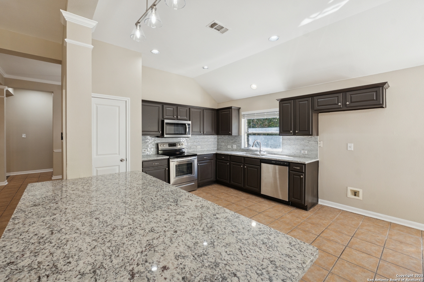 1815 Indian Paint Brush Road San Antonio, TX 78232 - Photo 10 of 38 a large kitchen with stainless steel appliances kitchen island granite countertop a sink refrigerator and cabinets