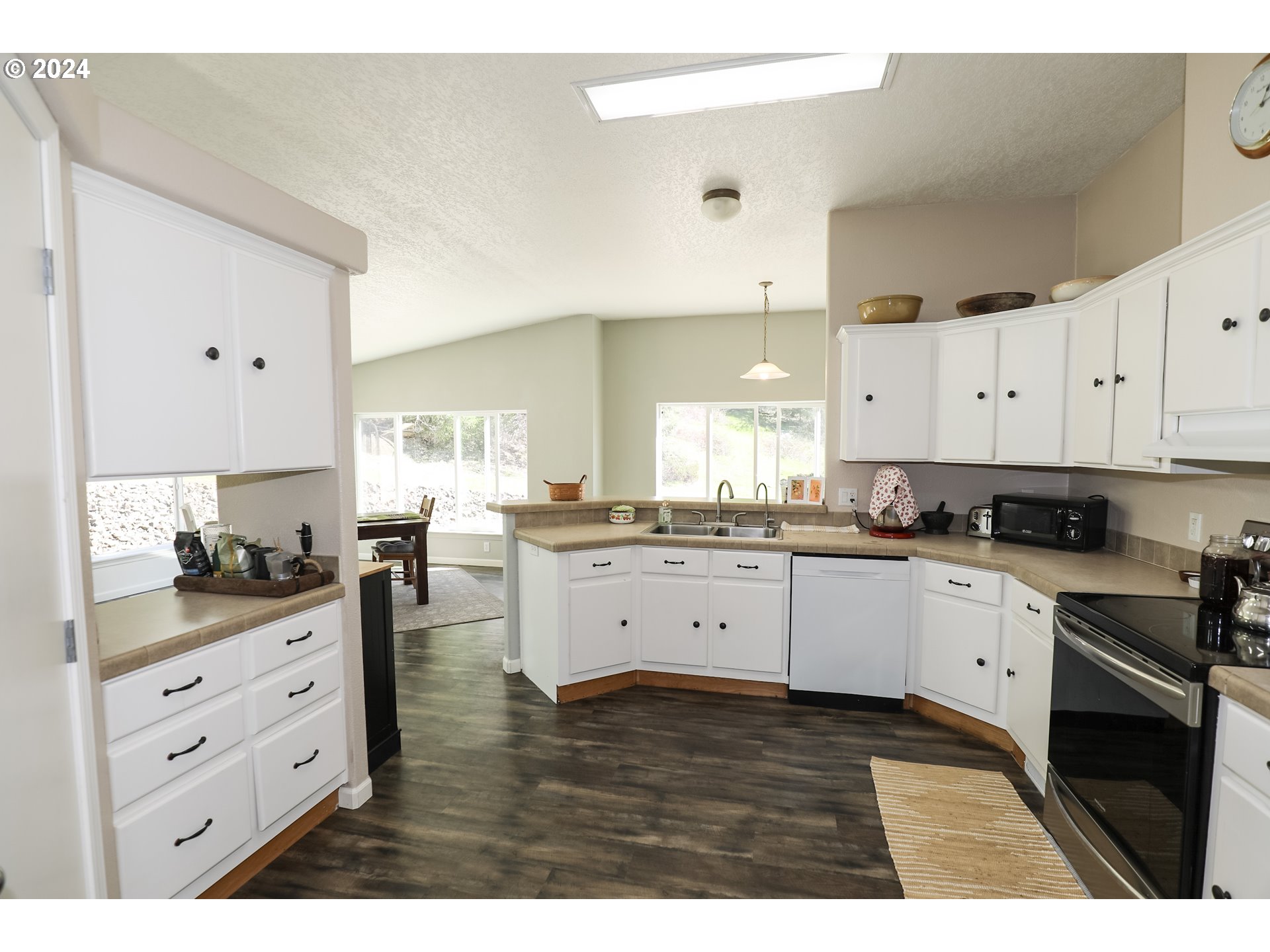 6910 Upper Olalla Road Winston, OR 97496 - Photo 23 of 48 a kitchen with white cabinets and appliances