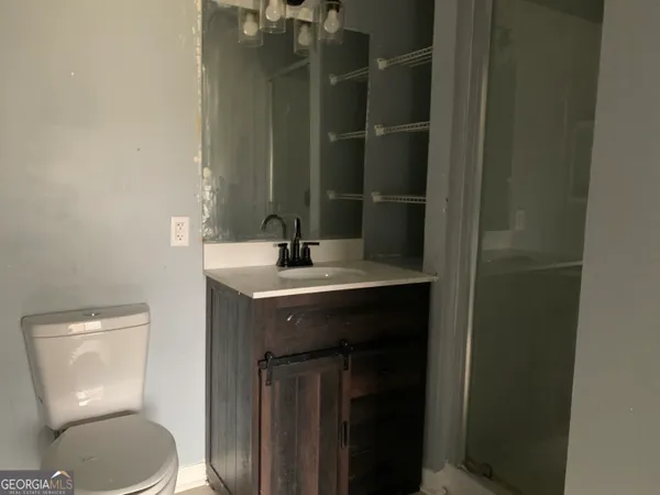 a bathroom with a toilet a sink and mirror