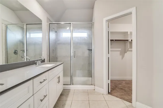 a spacious bathroom with a granite countertop sink mirror and shower