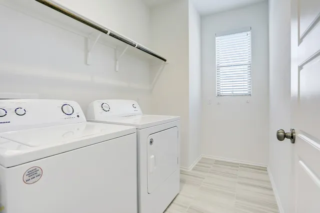an empty room with chandelier fan and windows