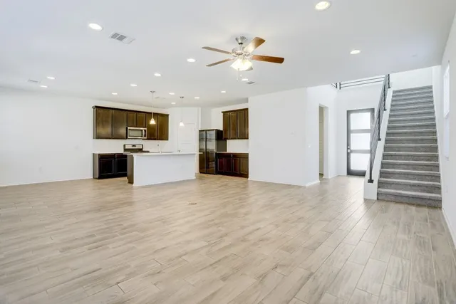 a view of a kitchen with a sink a refrigerator and a stove top oven