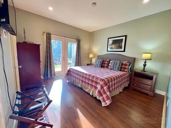 a bedroom with bed and wooden floor