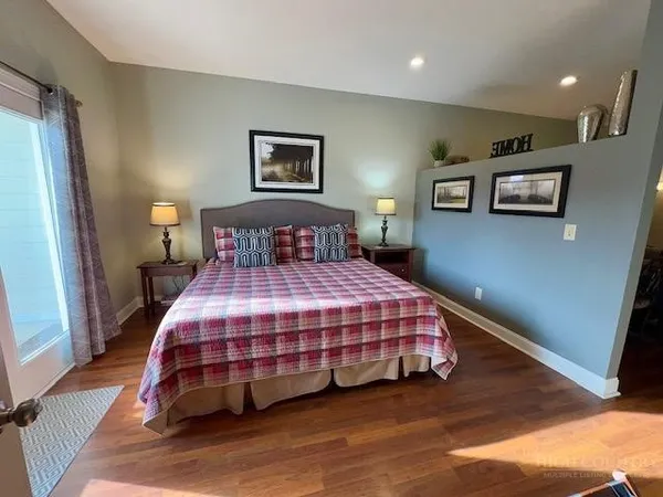 a bedroom with a bed and painting on the wall
