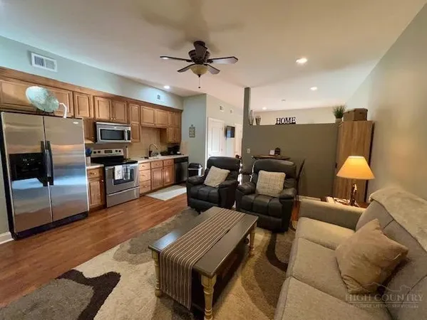 a living room with furniture and kitchen view