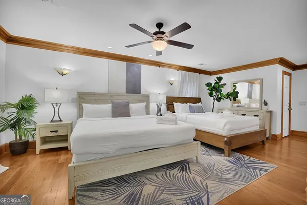 a bedroom with a large bed and a large window with wooden floor