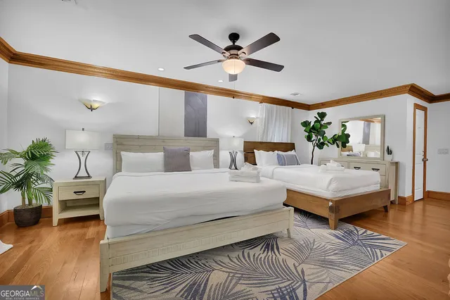 a bedroom with a large bed and a large window with wooden floor