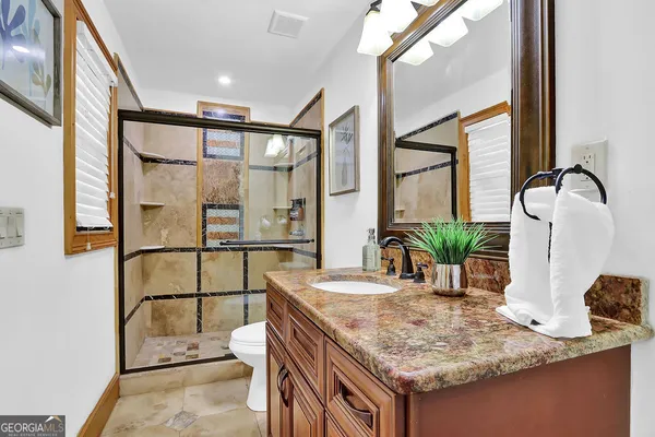 a bathroom with a sink toilet a mirror and bathtub