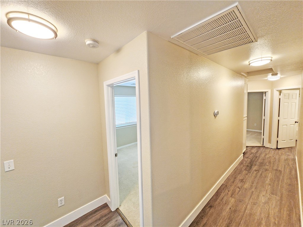 4591 Stoneham Street Pahrump, NV 89061 - Photo 29 of 42 A well-lit hallway with durable flooring leads to inviting spaces within this residence.