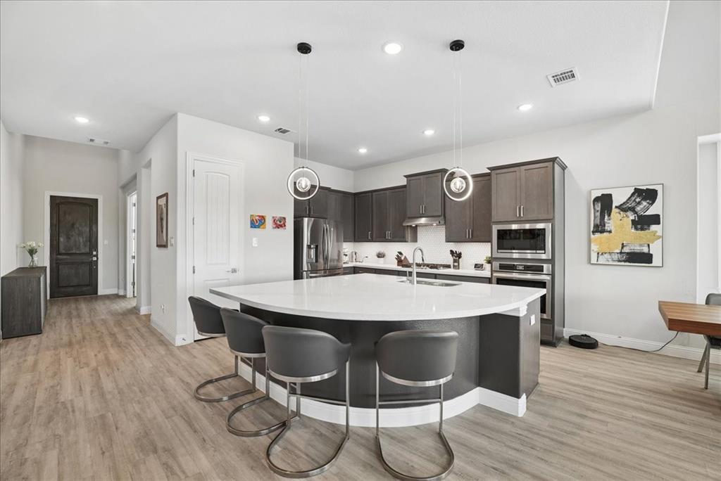 2721 Rotherham Street Prosper, TX 75078 - Photo 5 of 37 a large kitchen with a table and chairs