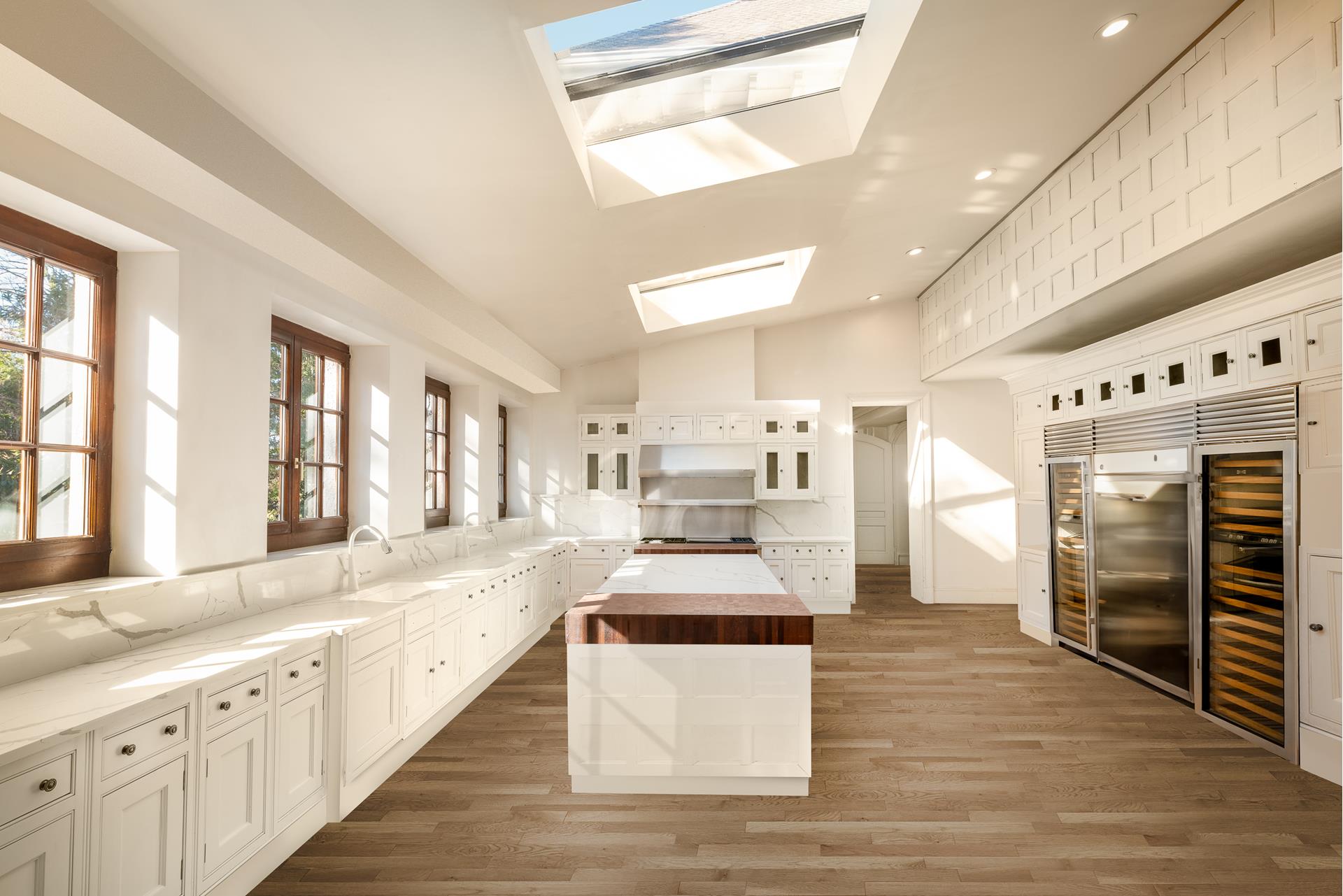 5040 Independence Avenue Bronx, NY 10471 - Photo 10 of 27 a large white kitchen with cabinets and wooden floor