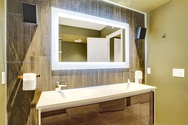 a close view of white kitchen with sink and cabinetry