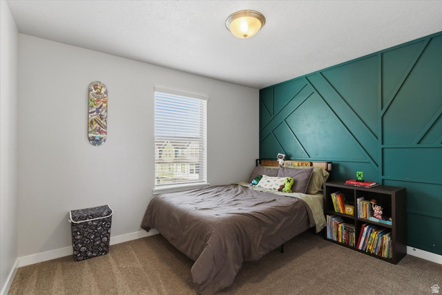 370 West Knights Lane Layton, UT 84041 - Photo 28 of 31 Bedroom featuring a teal geometric accent wall, neutral carpeting, and a single window with blinds