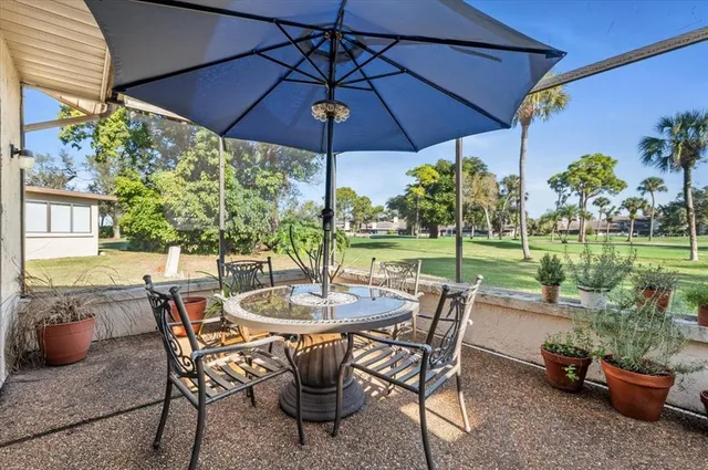 a view of a patio with table and chairs under an umbrella