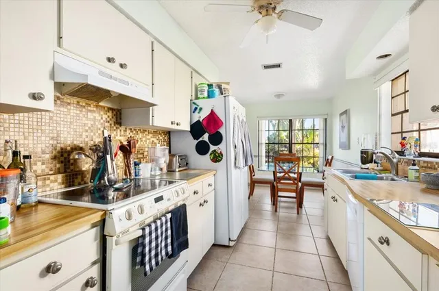 a large kitchen with stainless steel appliances kitchen island granite countertop a sink and cabinets