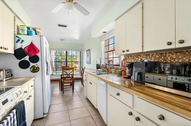a kitchen with white cabinets and sink