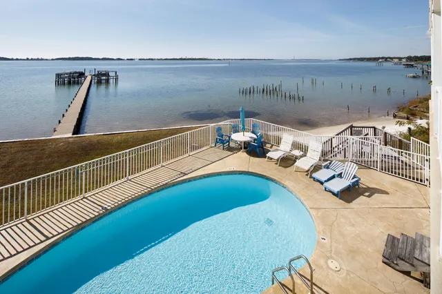 a view of a patio with table and chairs with wooden floor and fence