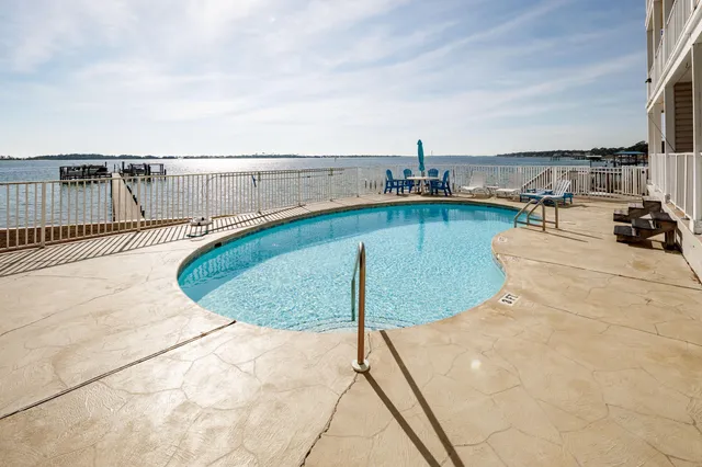 a view of a white house with large windows and a car park in front of it