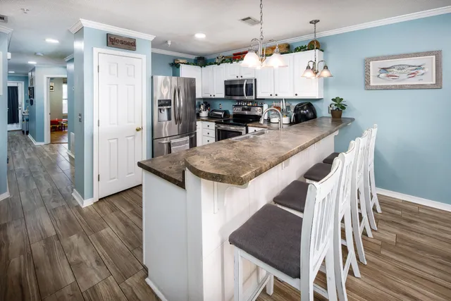 a kitchen with stainless steel appliances granite countertop a stove a sink and a microwave