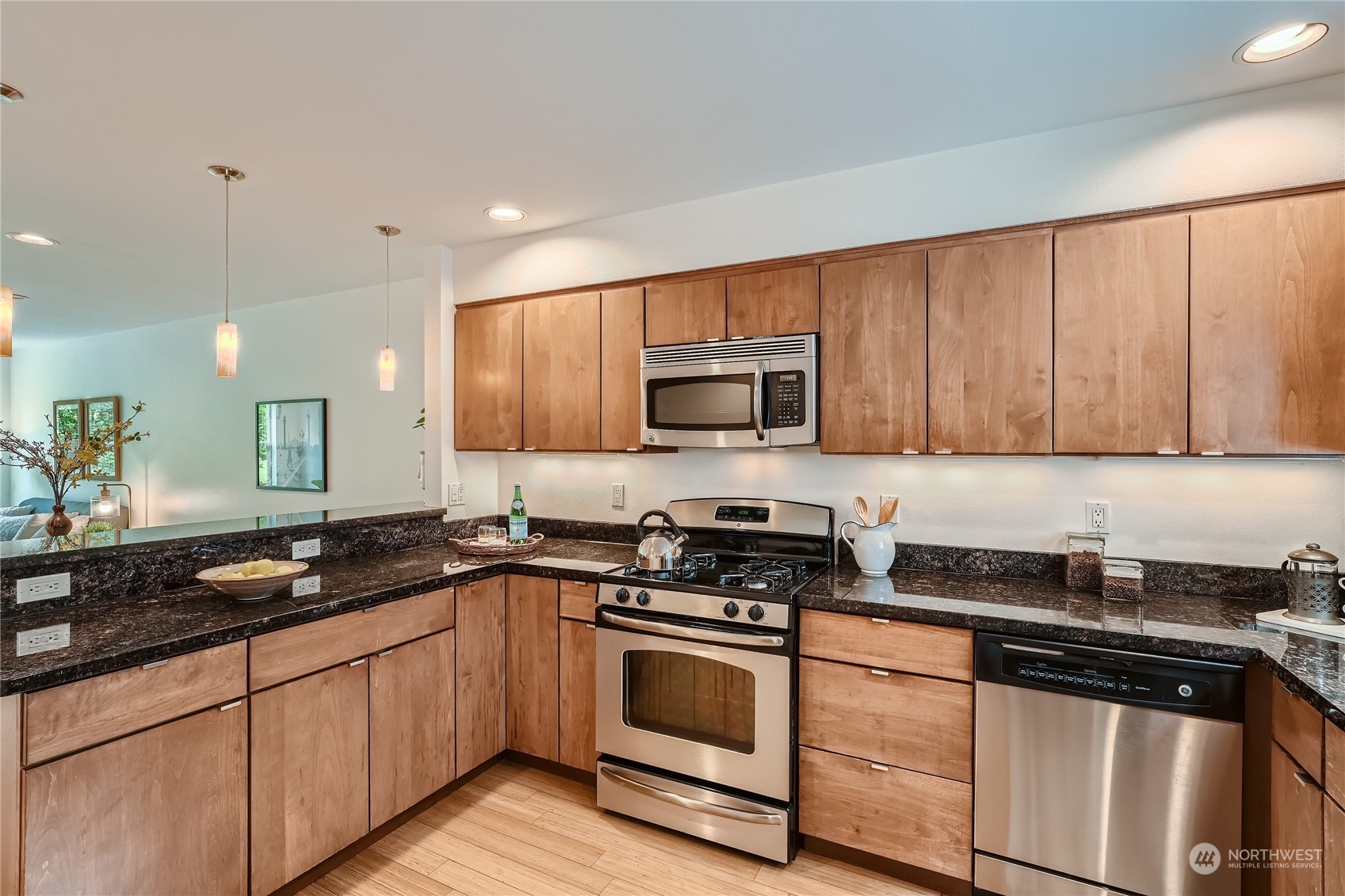 4313 South Webster Street, Unit B Seattle, WA 98118 - Photo 11 of 26 a kitchen with granite countertop stainless steel appliances a sink a stove cabinets and a counter top space