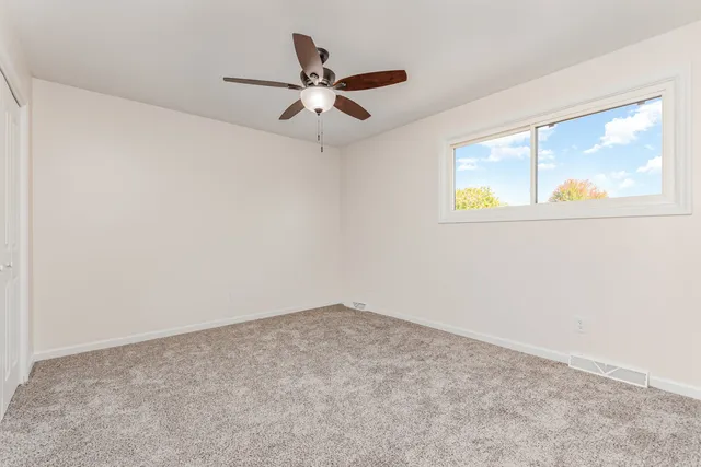 a view of a big room with wooden floor and windows