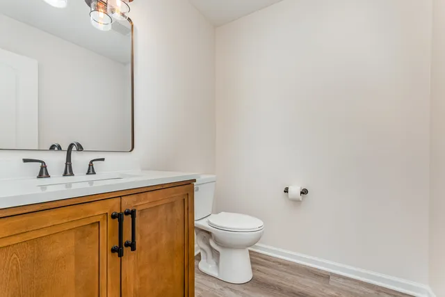 a bathroom with a toilet a sink and mirror