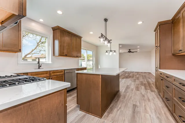 a kitchen with granite countertop a sink cabinets and wooden floor