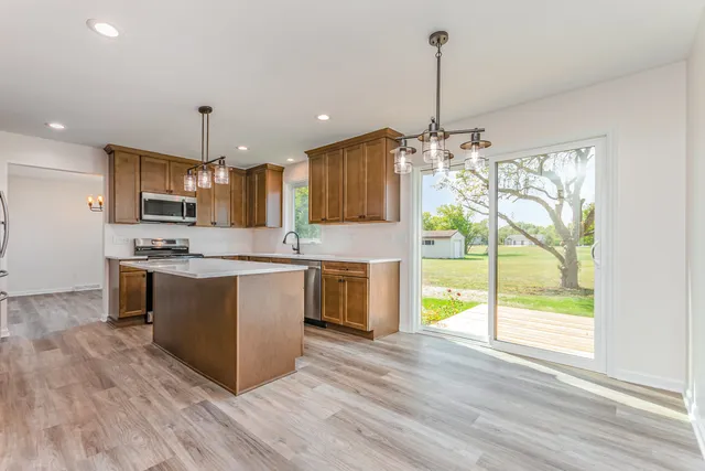 a kitchen with kitchen island granite countertop a stove and a wooden floors