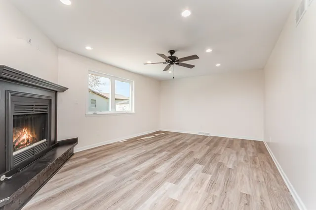 a view of an empty room with a fireplace and a window