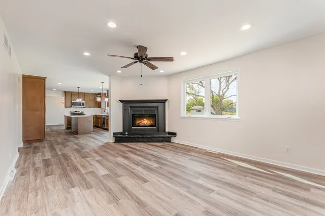 a view of an empty room with a fireplace and a window