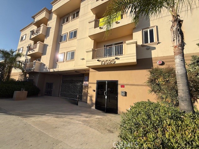 13525 Vanowen Street, Unit 102 Van Nuys, CA 91405 - Photo 2 of 13 a front view of a building with a garden