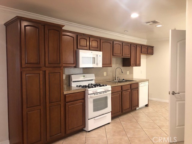 13525 Vanowen Street, Unit 102 Van Nuys, CA 91405 - Photo 3 of 13 a kitchen with stainless steel appliances granite countertop a refrigerator and a stove top oven