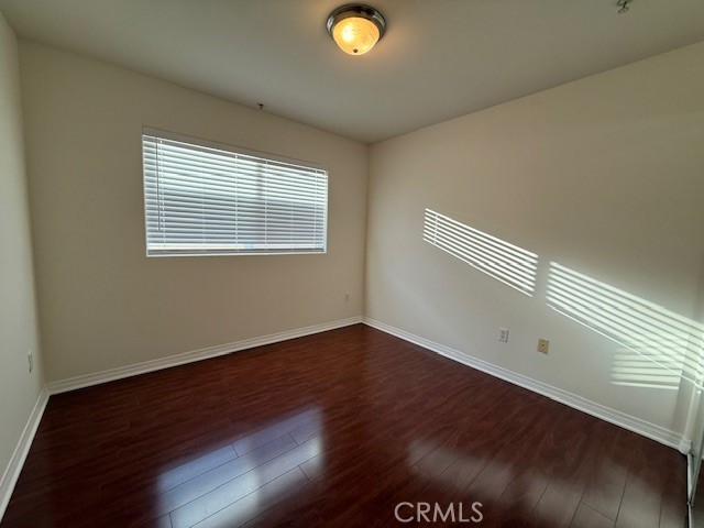 13525 Vanowen Street, Unit 102 Van Nuys, CA 91405 - Photo 10 of 13 a view of an empty room with wooden floor and a window