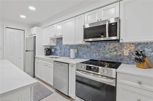 a kitchen with stainless steel appliances a stove microwave and sink