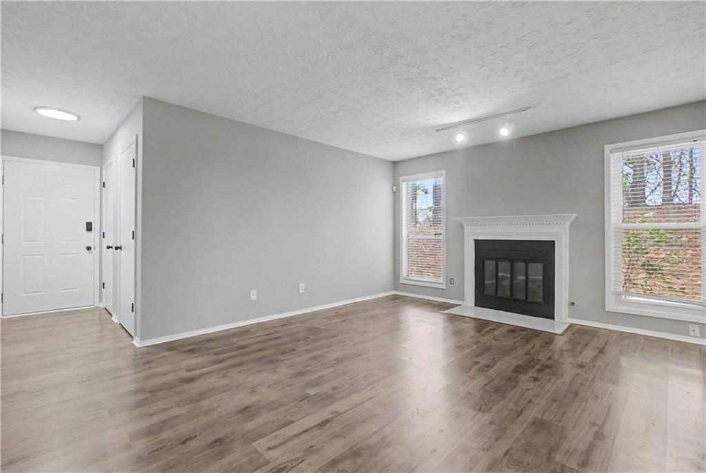 2011 Canyon Point Circle Roswell, GA 30076 - Photo 8 of 22 an empty room with wooden floor a fireplace and windows