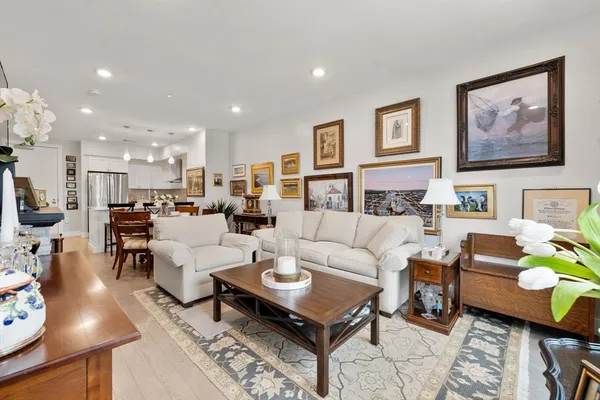 a living room with furniture and a dining table with rug