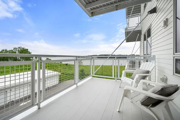 a view of a roof deck with couches and wooden floor