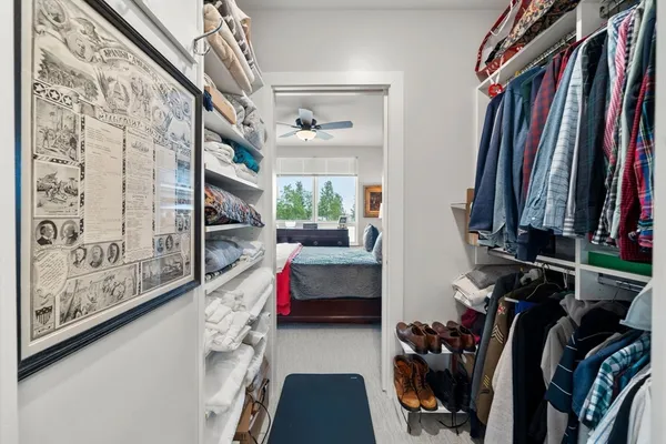 a view of walk in closet with clothes and shoes