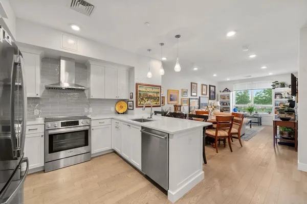 a kitchen with appliances a sink a counter top space and cabinets