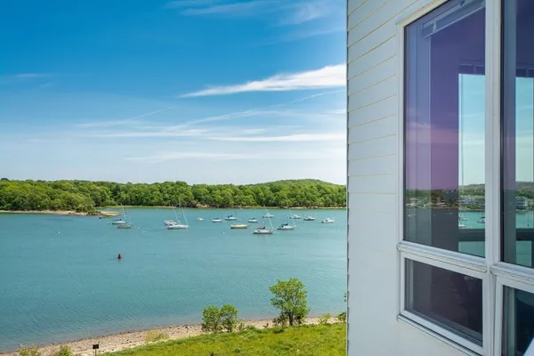 a view of a pool with lawn chairs and a dining table