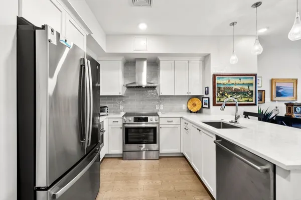 a kitchen with a sink stainless steel appliances and white cabinets