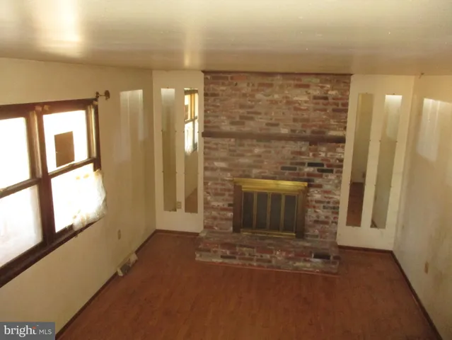 a view of a hallway with an empty room and a fireplace